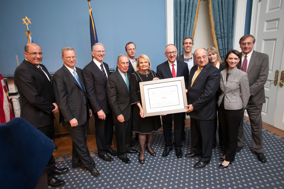 12 people posing for a photo while holding a framed certificate