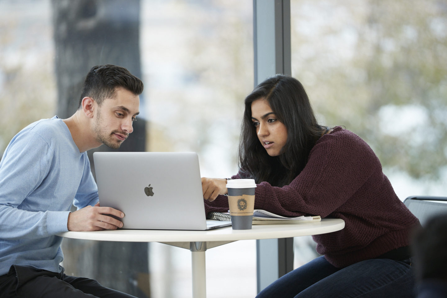 Two students collaborating on a laptop